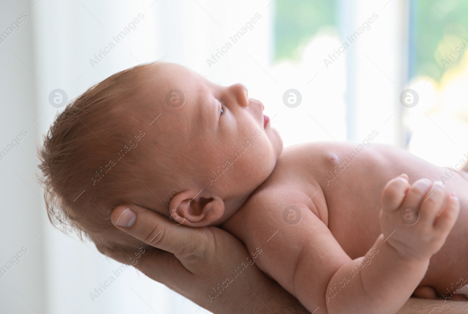 Photo of Father holding his newborn baby at home, closeup