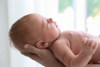 Father holding his newborn baby at home, closeup