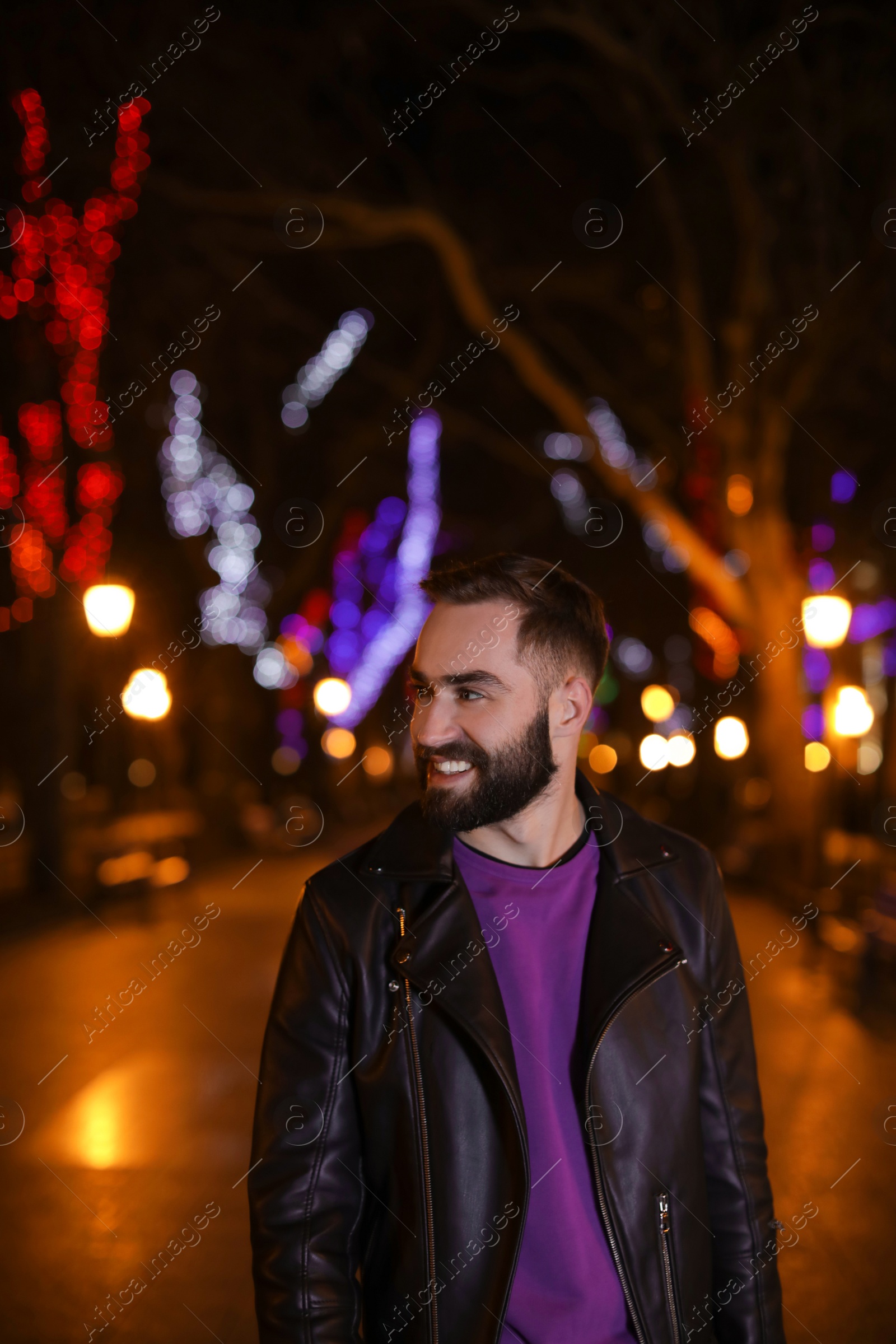 Photo of Handsome young man spending time in city at night
