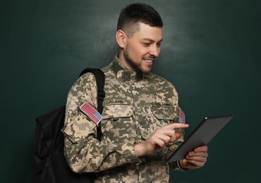 Cadet with backpack and tablet near chalkboard. Military education