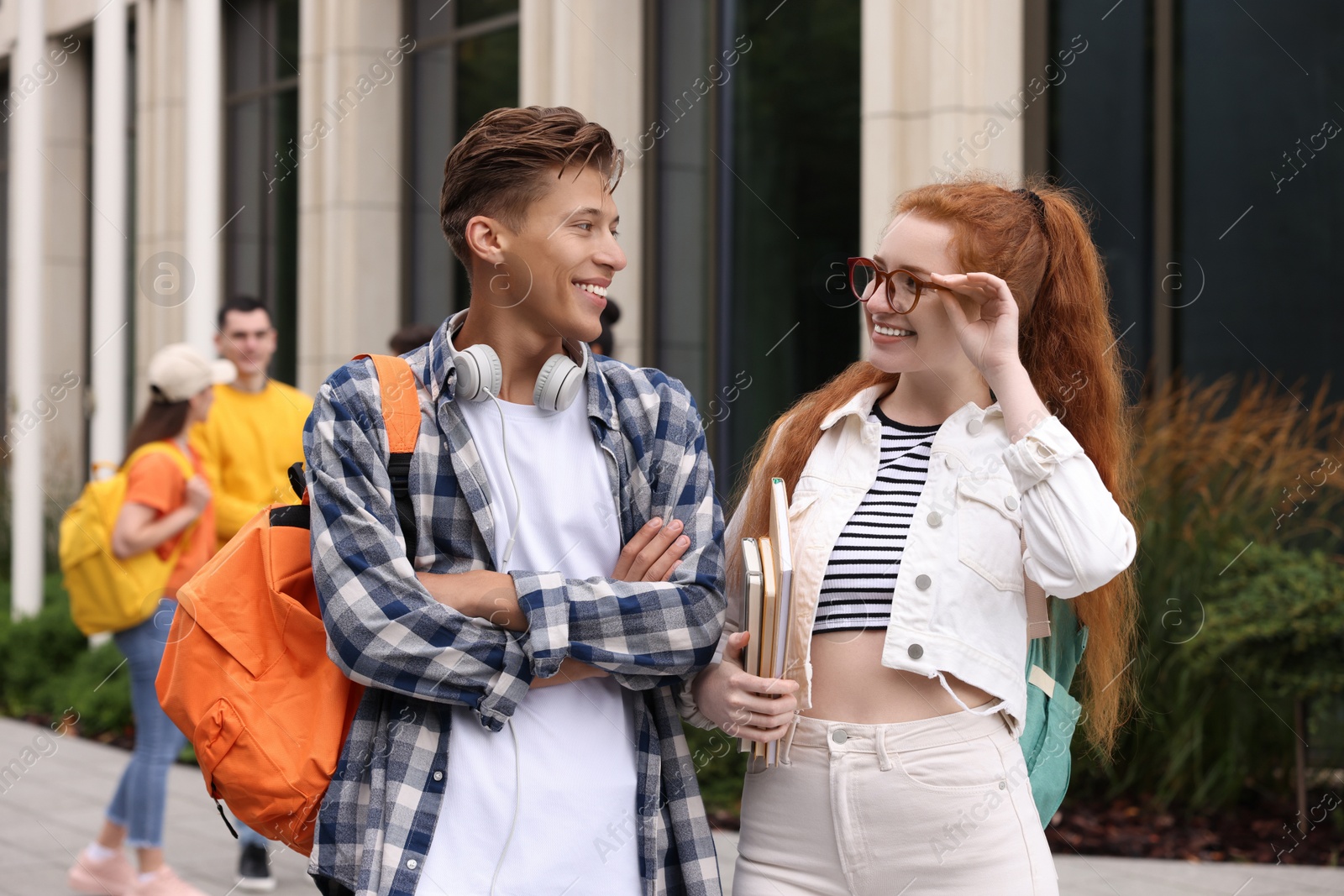 Photo of Happy young students spending time together outdoors