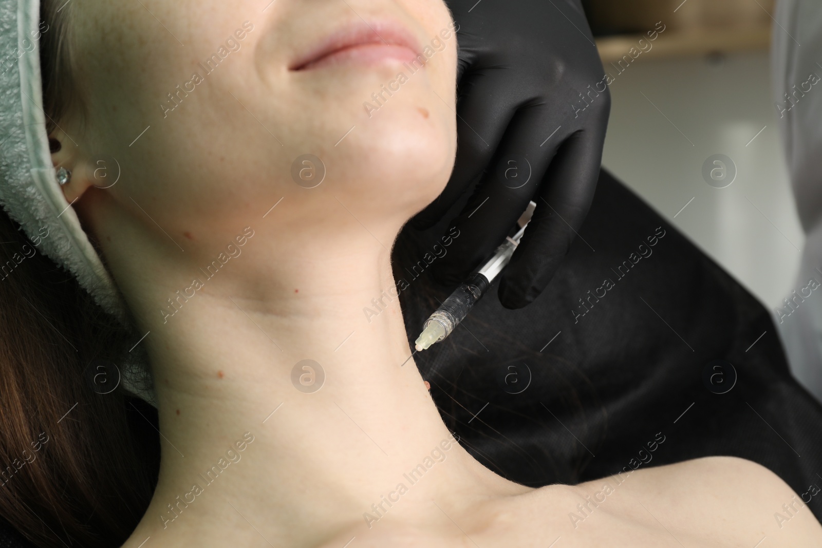 Photo of Cosmetologist giving neck injection to patient, closeup. Cosmetic surgery