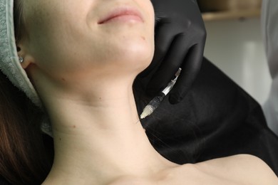 Photo of Cosmetologist giving neck injection to patient, closeup. Cosmetic surgery
