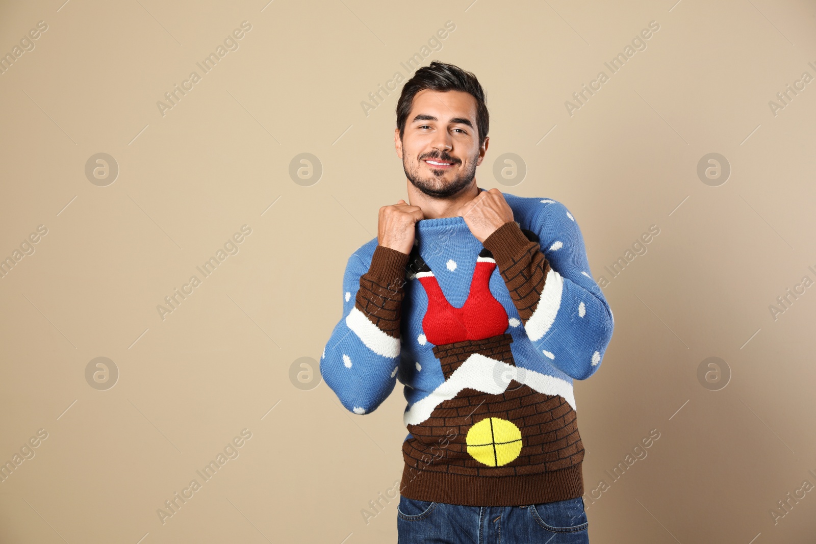 Photo of Portrait of happy man in Christmas sweater on beige background