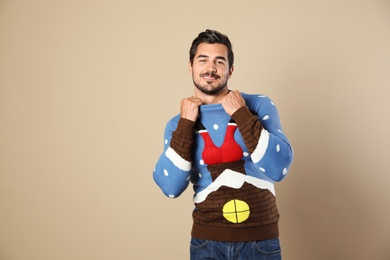 Photo of Portrait of happy man in Christmas sweater on beige background