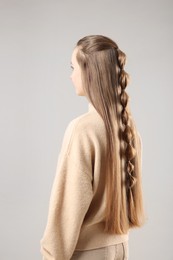 Woman with braided hair on grey background