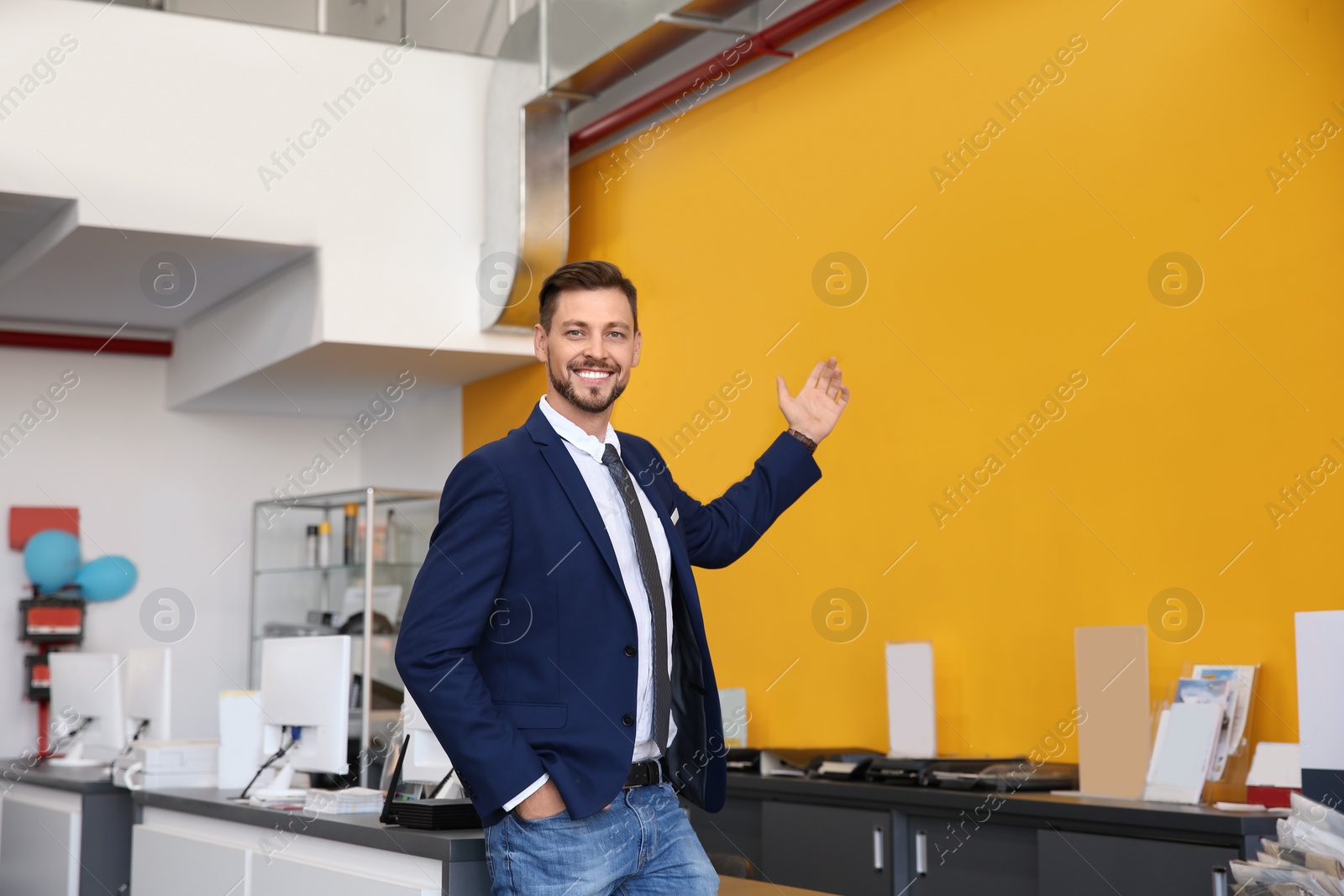 Photo of Salesman standing in modern auto dealership. Buying new car