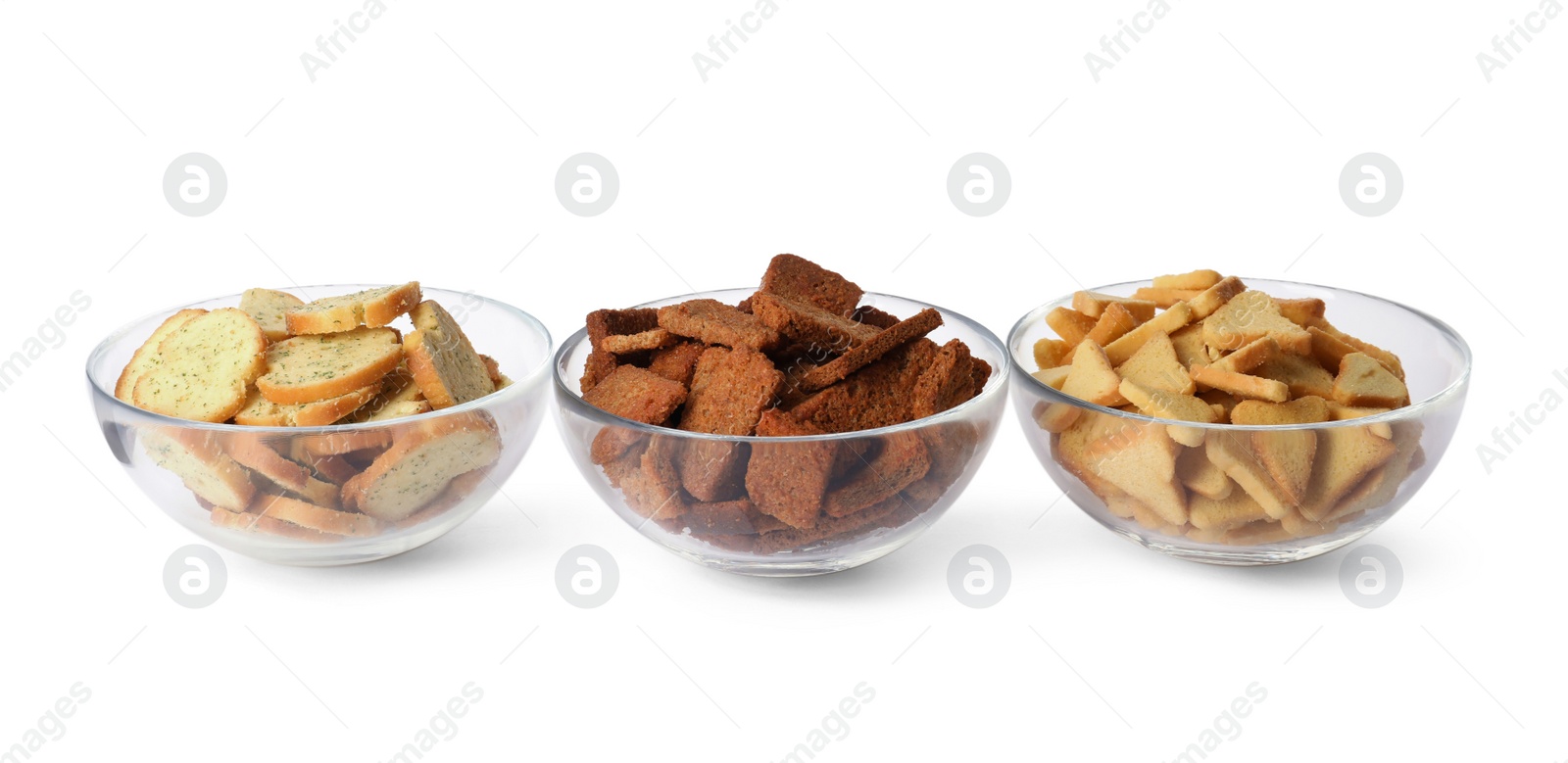 Photo of Different crispy rusks in bowls on white background