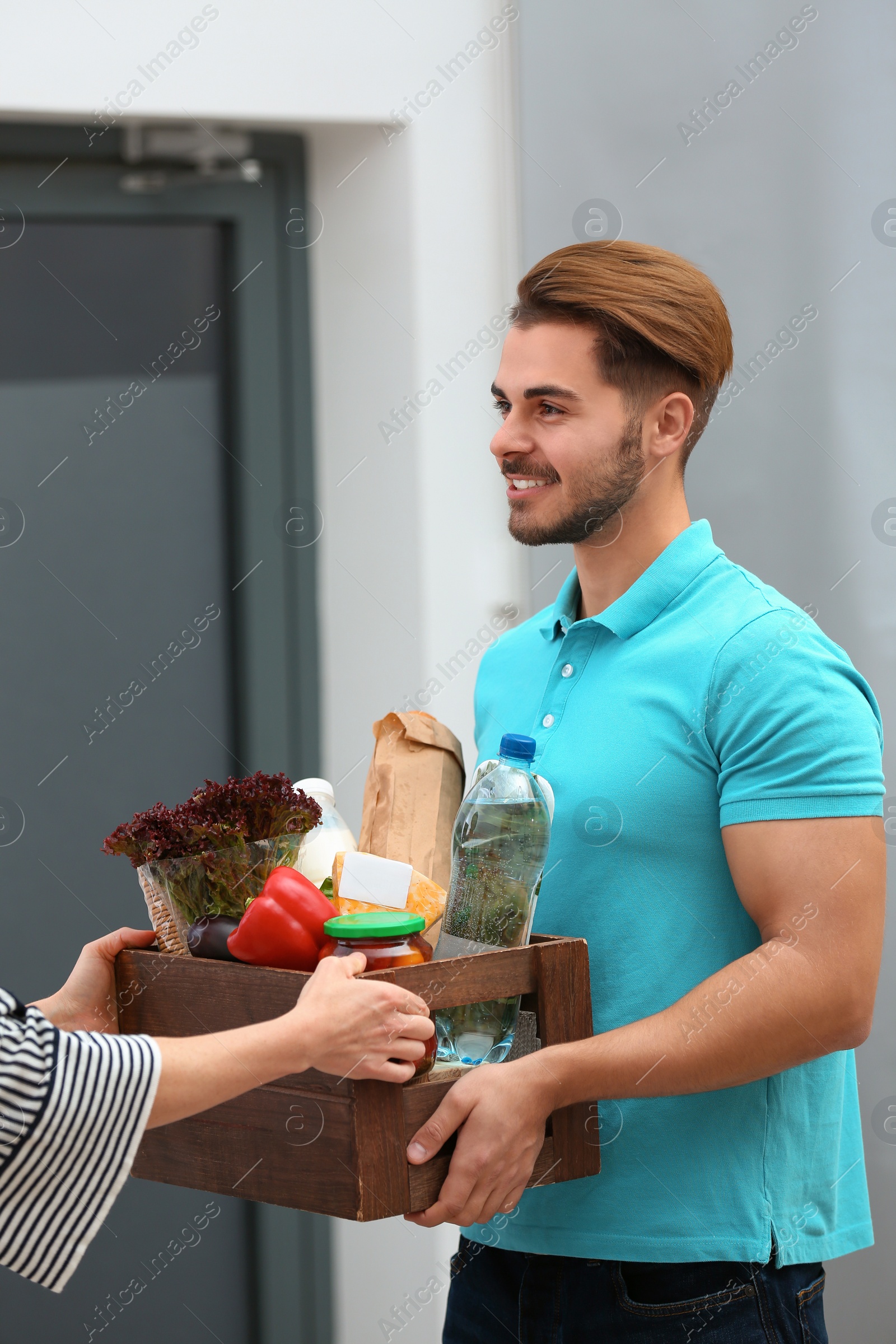 Photo of Male courier delivering food to client indoors