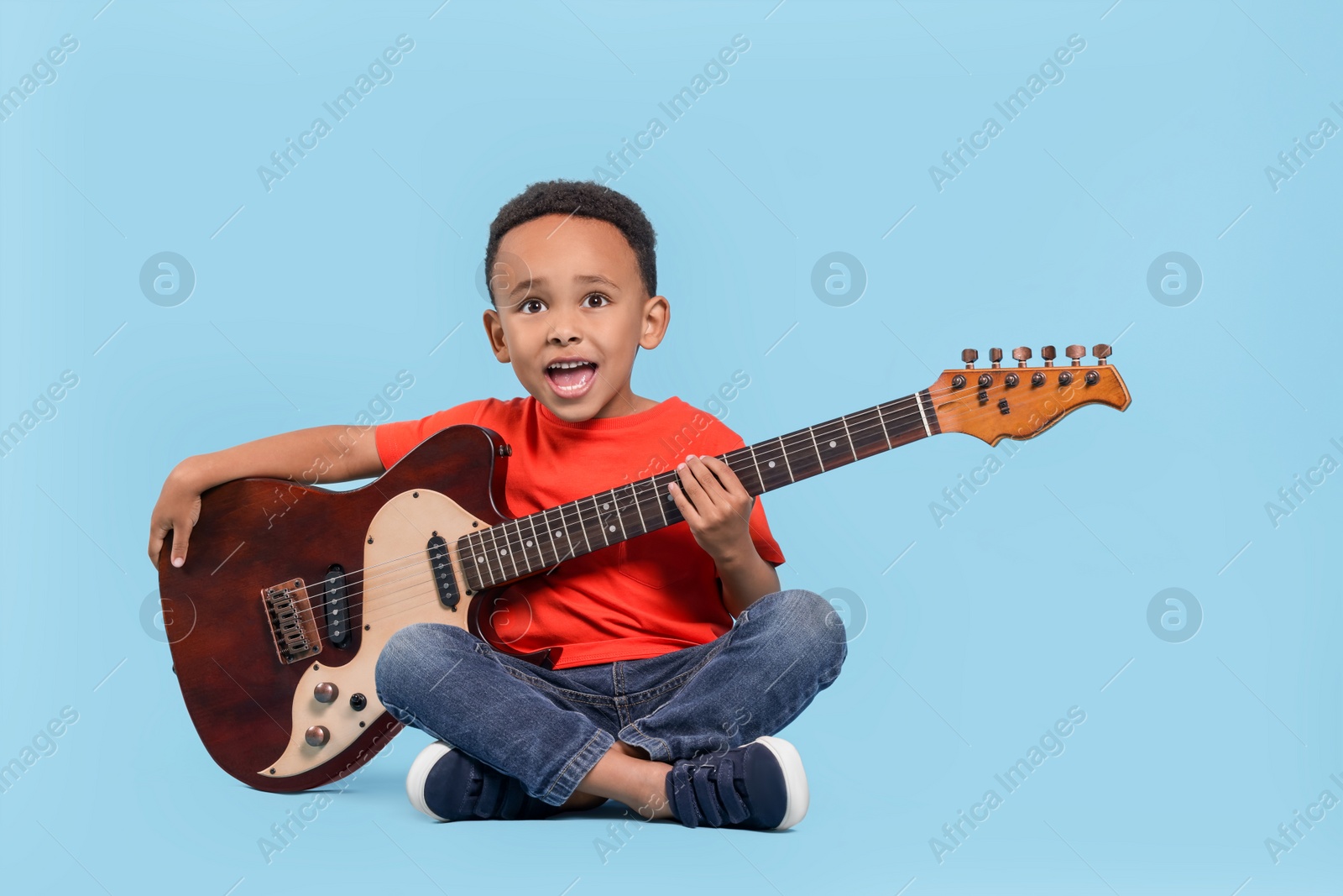 Photo of Cute African-American boy with electric guitar on turquoise background