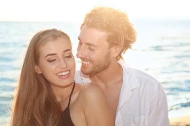 Photo of Romantic young couple in beachwear spending time together on seashore