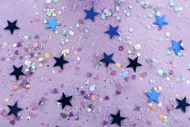 Photo of Shiny glitter on lilac background, flat lay