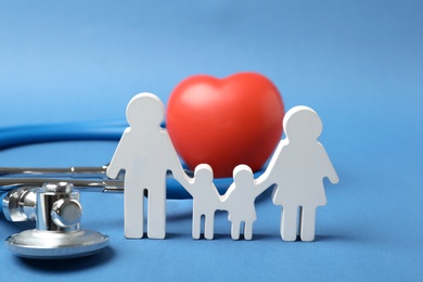 Photo of Family figure with stethoscope and heart on color background. Life insurance concept