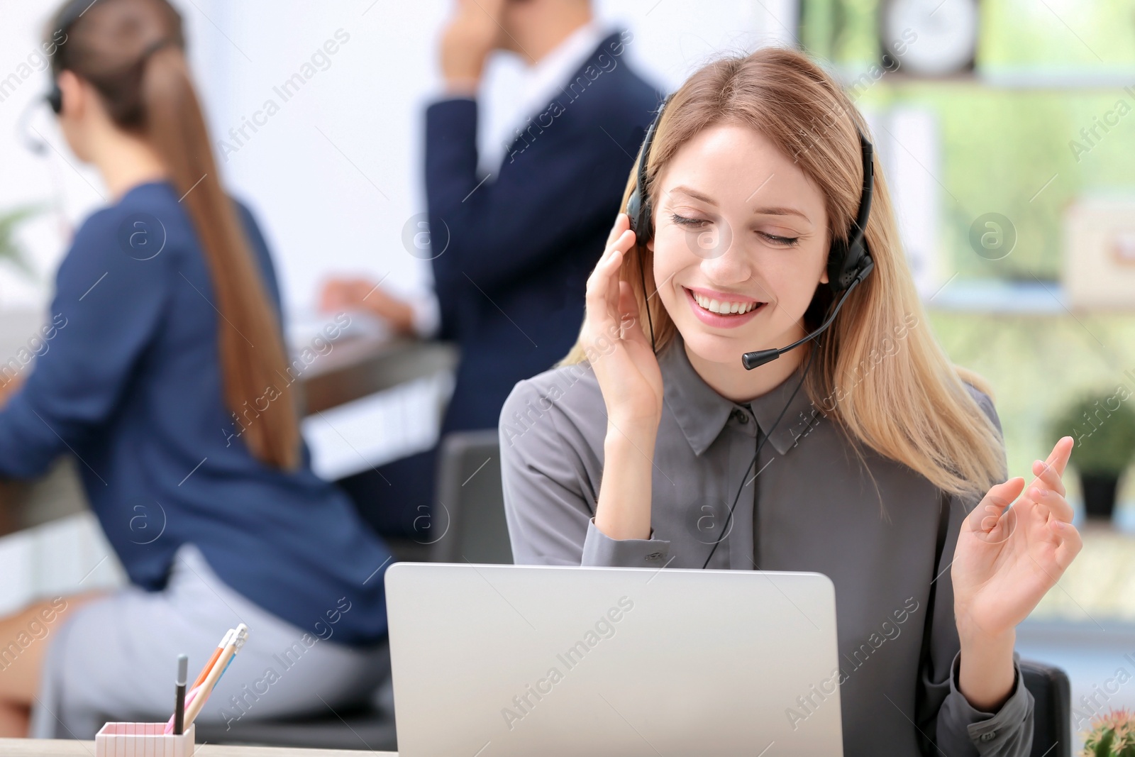 Photo of Young female receptionist with headset in office