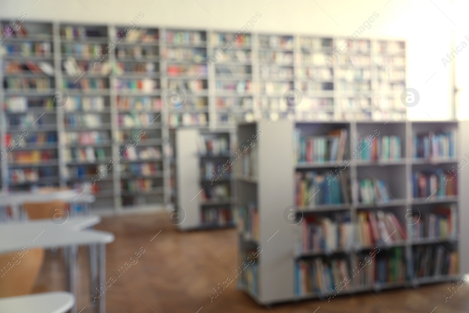 Photo of Blurred view of library interior with bookcases and tables