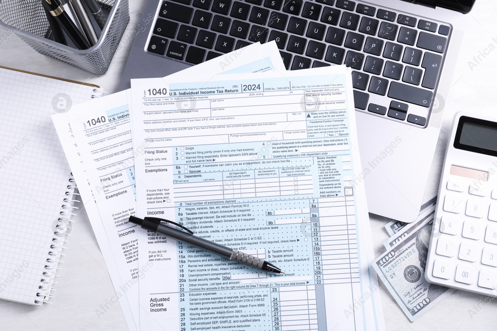 Photo of Tax forms, money, stationery, laptop and calculator on light grey table, flat lay