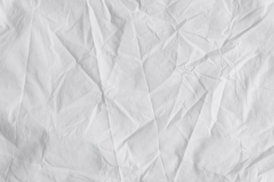 Photo of Crumpled white fabric as background, top view