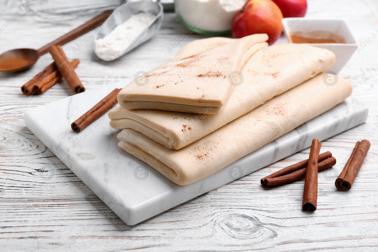 Photo of Board with raw wheat dough on wooden table