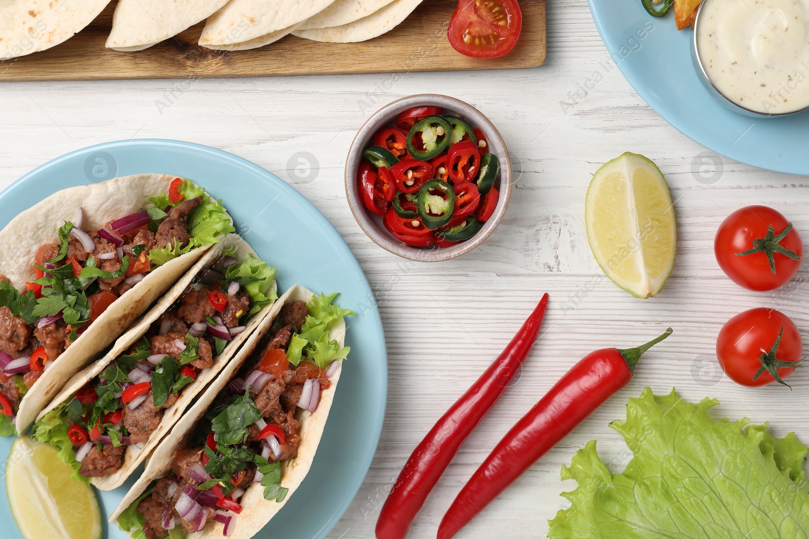 Photo of Flat lay composition with delicious tacos on wooden table