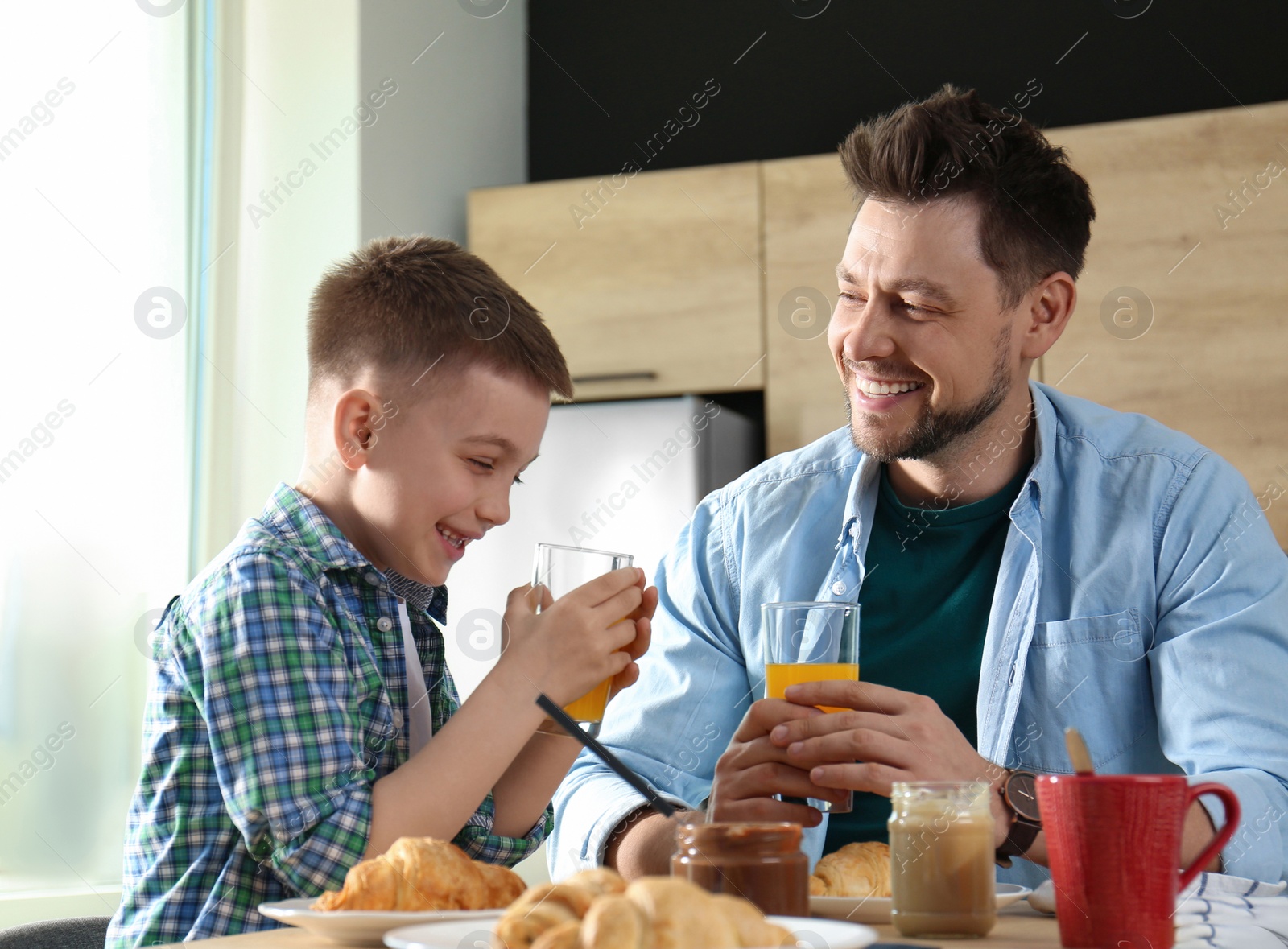 Photo of Dad and son having breakfast together in kitchen