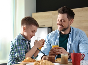 Dad and son having breakfast together in kitchen