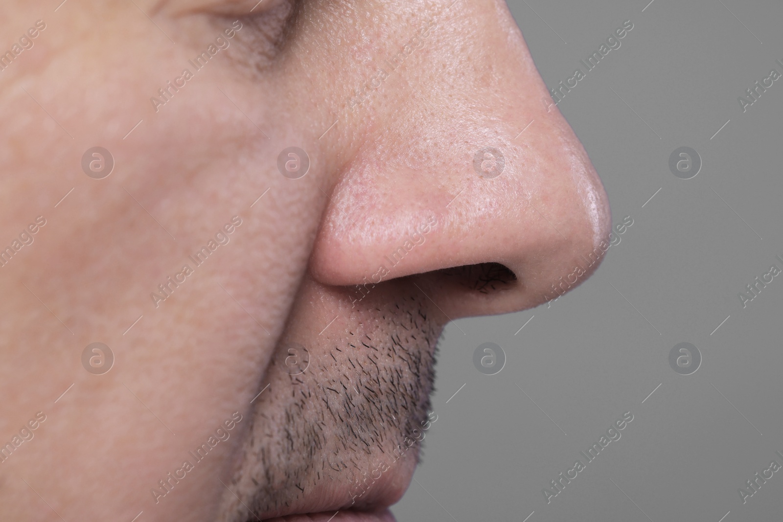 Photo of Closeup view of man with normal skin on grey background