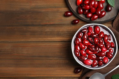 Delicious dogwood jam with berries on wooden table, flat lay. Space for text