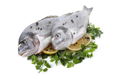 Photo of Raw dorado fish, parsley, lemon slices and peppercorns isolated on white