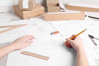 Woman creating packaging design at table, closeup