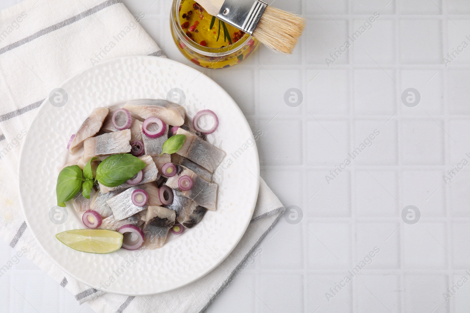 Photo of Plate with tasty fish, onion and marinade on light tiled table, flat lay. Space for text