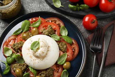 Delicious burrata salad served on grey table, flat lay