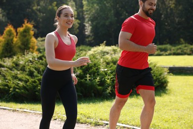 Healthy lifestyle. Happy couple running in park on sunny day