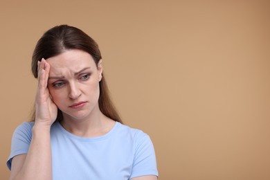 Photo of Portrait of sad woman on beige background, space for text