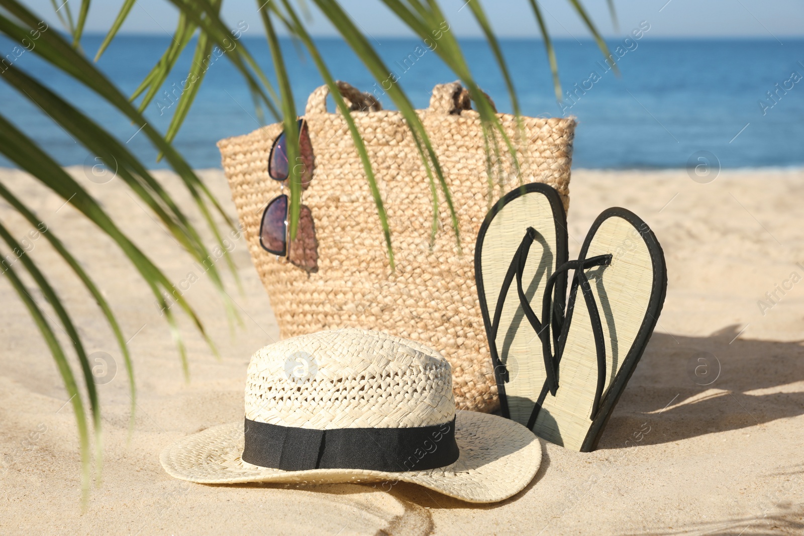 Photo of Stylish beach accessories on sandy sea shore