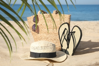 Photo of Stylish beach accessories on sandy sea shore