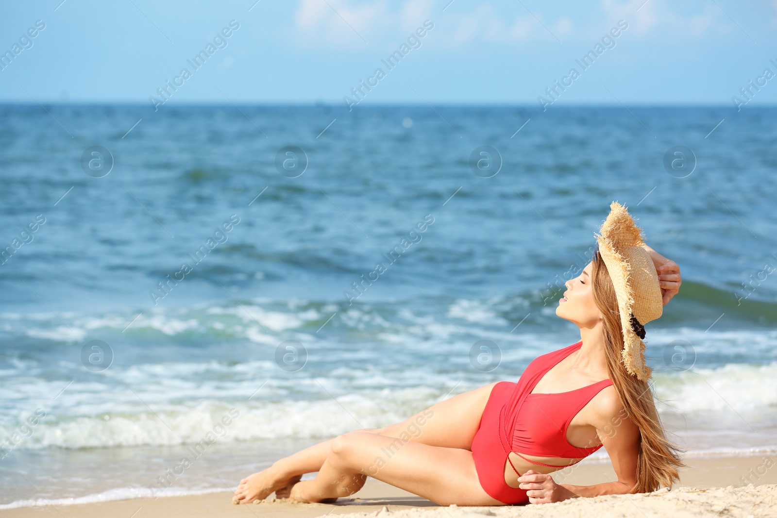 Photo of Attractive young woman in beautiful one-piece swimsuit on beach