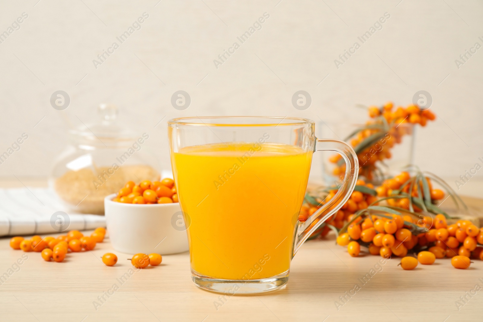 Photo of Delicious sea buckthorn tea and fresh berries on wooden table