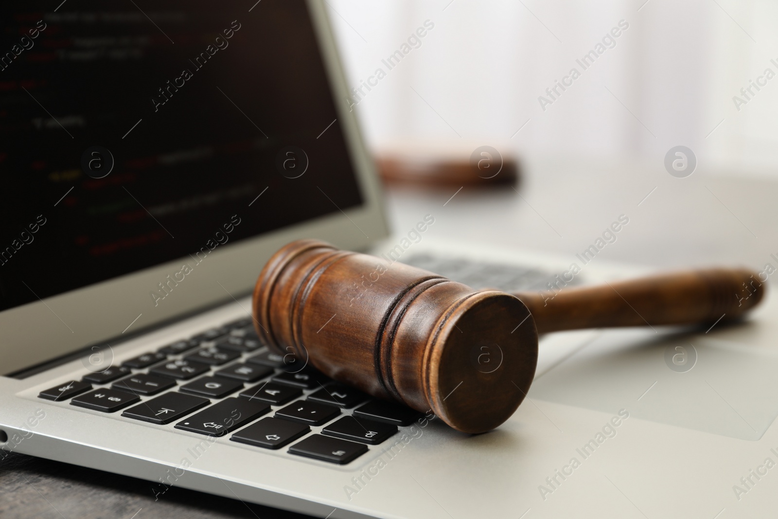 Photo of Laptop and gavel on table indoors, closeup. Cyber crime