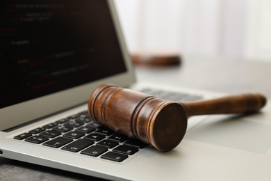 Laptop and gavel on table indoors, closeup. Cyber crime