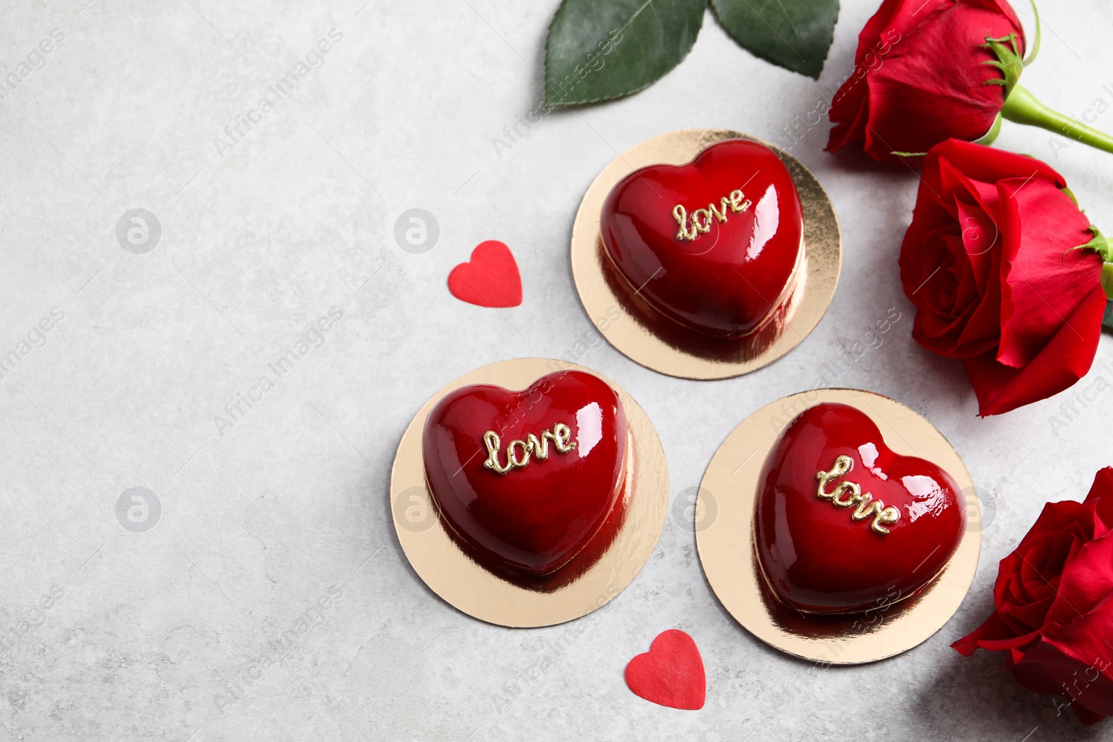 Photo of St. Valentine's Day. Delicious heart shaped cakes and roses on light table, flat lay. Space for text