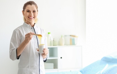 Photo of Female beautician with wax for epilation in salon