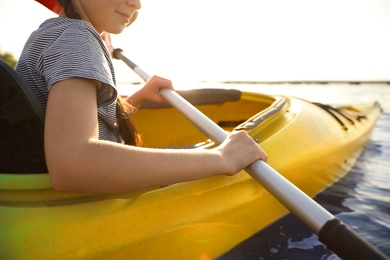 Photo of Happy little girl kayaking on river, closeup. Summer camp activity