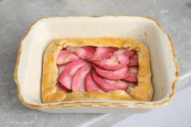 Photo of Tasty galette with apples on light grey table, closeup