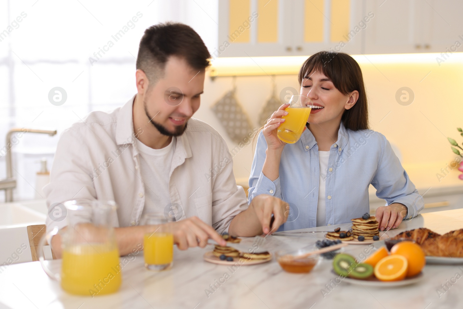 Photo of Happy couple having tasty breakfast at home