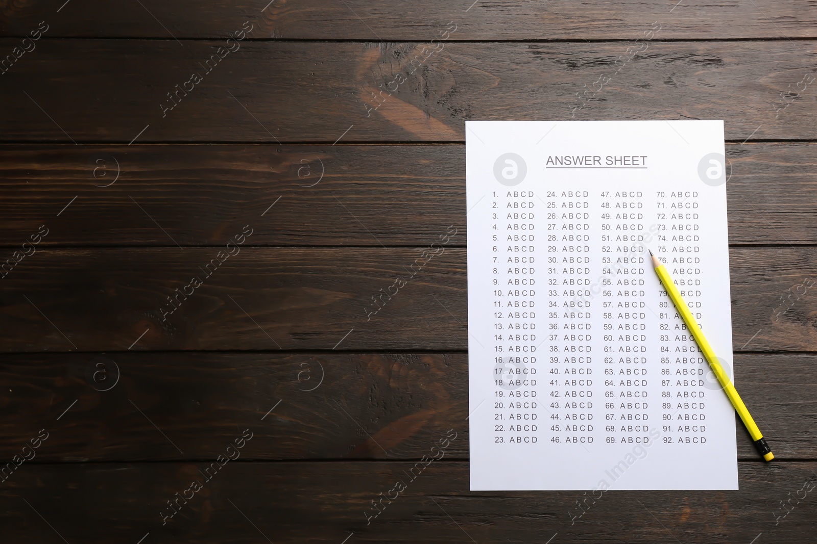 Photo of Answer sheet and pencil on wooden background, top view with space for text