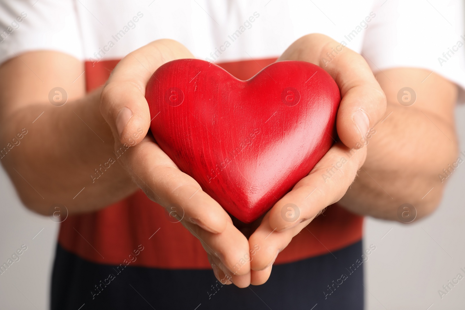 Photo of Man holding red decorative heart, closeup view