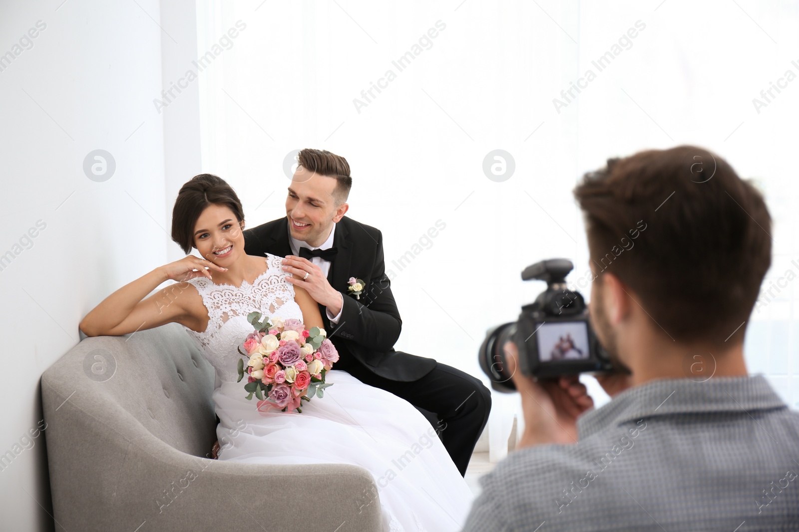 Photo of Professional photographer taking photo of wedding couple in studio