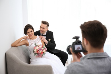 Professional photographer taking photo of wedding couple in studio