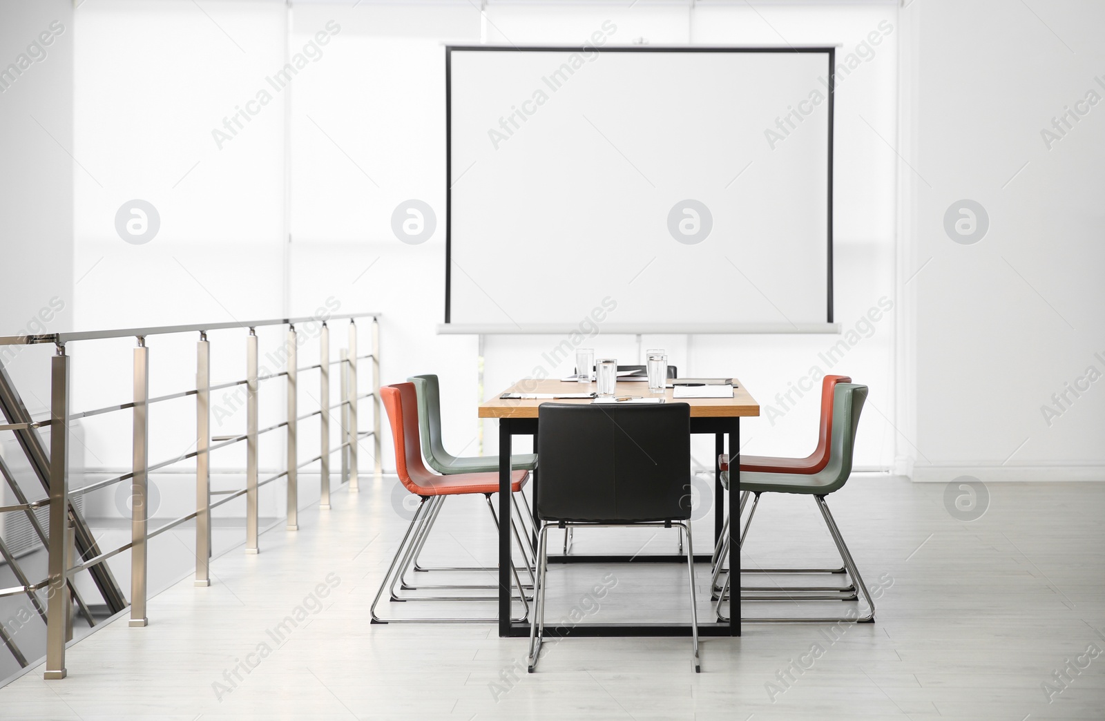 Photo of Modern meeting room interior with large table and projection screen