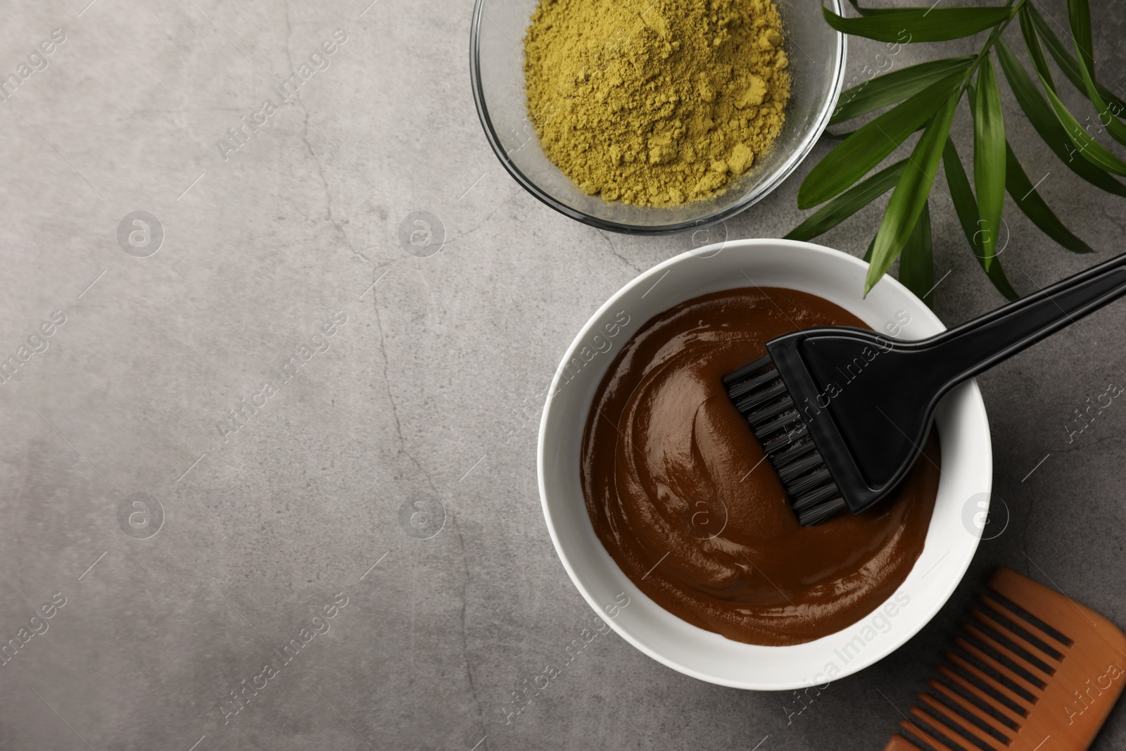 Photo of Henna cream with brush and powder, comb on light grey table, flat lay with space for text. Natural hair coloring